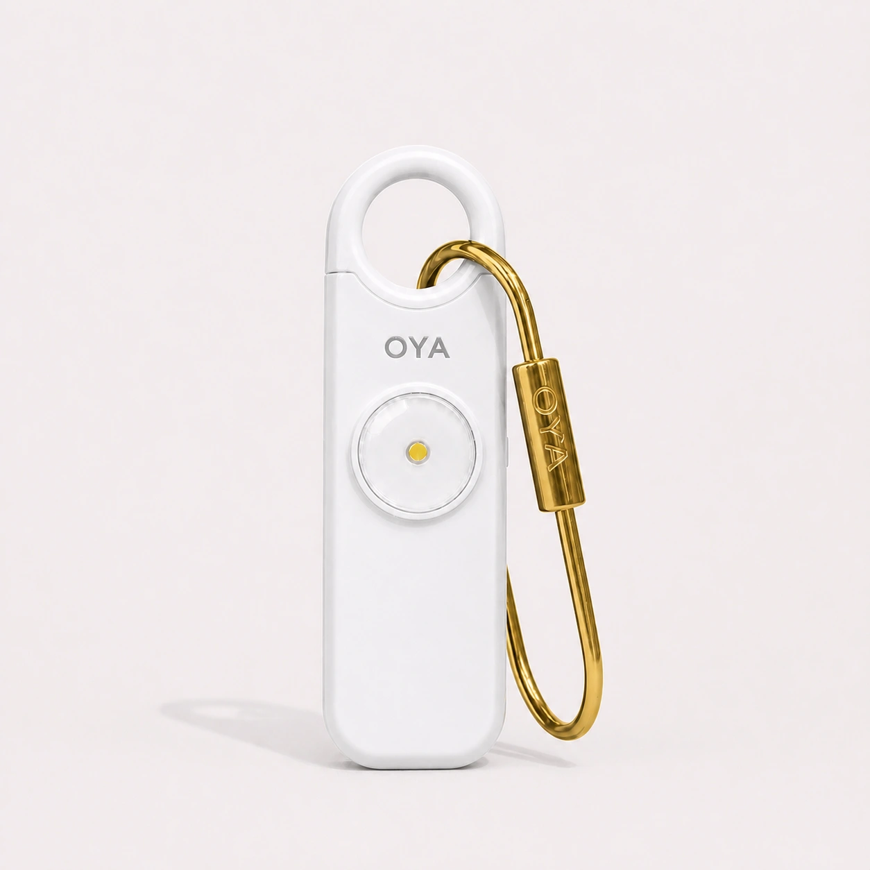 L’alarme personnelle OYA en Clear White avec son clip doré, sur un fond assorti à la teinte