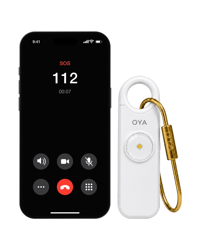 OYA Clear White, Anti-agression, sirène 130 dB et lampe, à côté d’un téléphone qui appelle les secours