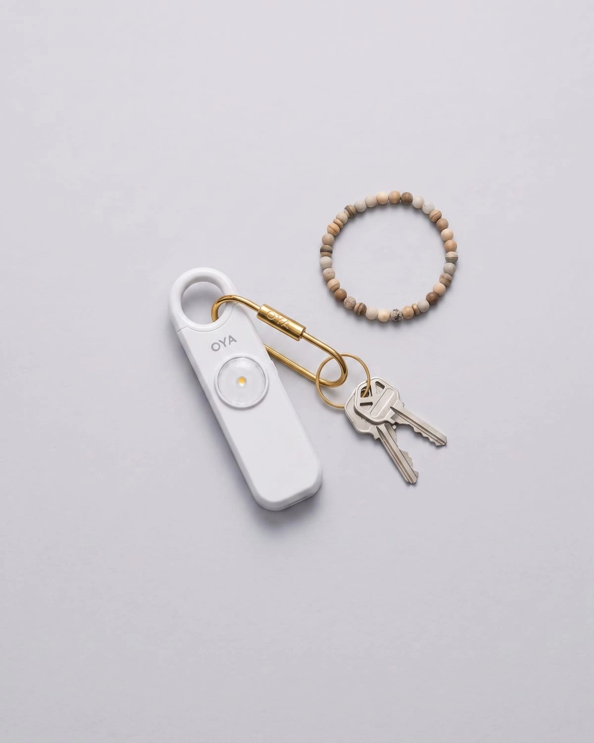 OYA Clear White, Anti-agression, sirène 130 dB et lampe, posée à plat avec des clés