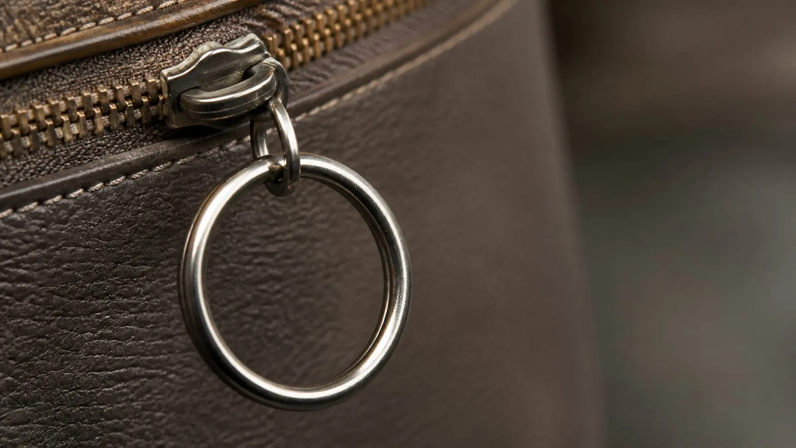 Gros plan sur un anneau de porte-clés en métal vide, accroché à un sac en cuir.